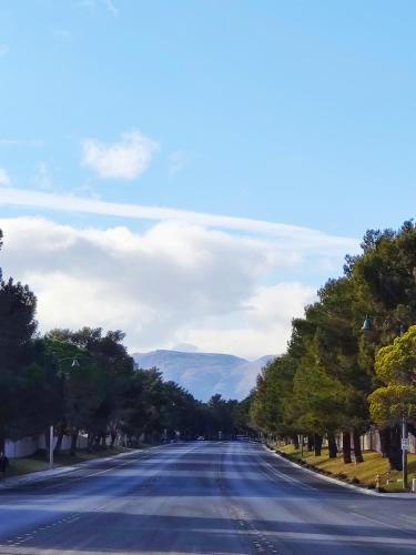 an empty road with trees and mountains in the distance at Nice Private Room Close to Red Rock & Las Vegas Strip #3 in Las Vegas