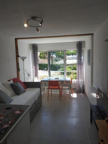 un salon avec un canapé et une table dans l'établissement Sète - Studio cabine vue mer, à Sète