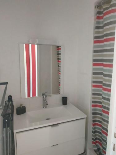 une salle de bain avec un lavabo blanc et un miroir dans l'établissement Sète - Studio cabine vue mer, à Sète