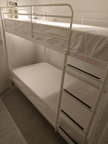 - un lit superposé blanc avec une échelle dans l'établissement Sète - Studio cabine vue mer, à Sète