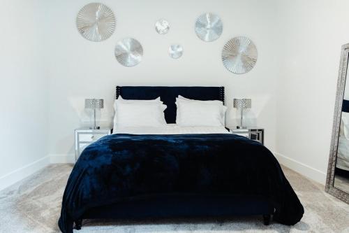 a bedroom with a bed with a black bedspread and mirrors at Sapphire Lux Queen Suite in Kamloops