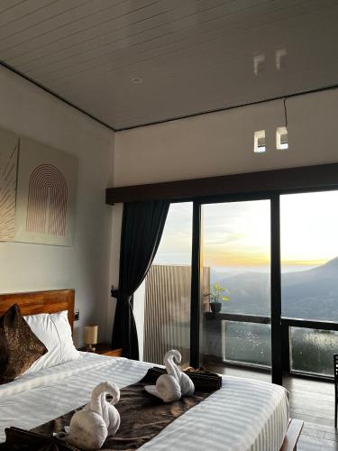 two swans are sitting on a bed in a bedroom at Dbila Cafe, Resto & Hotel in Kintamani