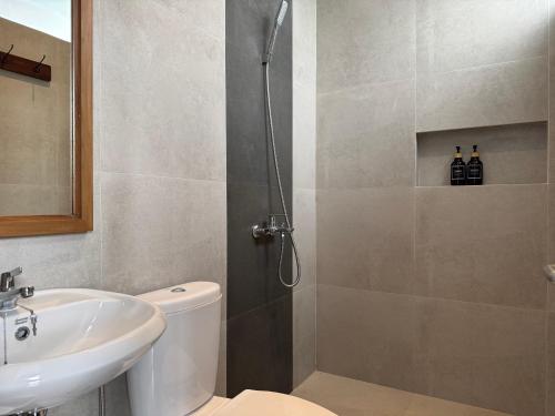 a bathroom with a shower and a toilet and a sink at Atmadeva Boutique Villas in Batu