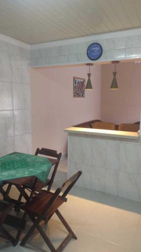 a room with a table and a chair and a kitchen at Linda casa Edícula "fundos do terreno" com piscina in Itanhaém
