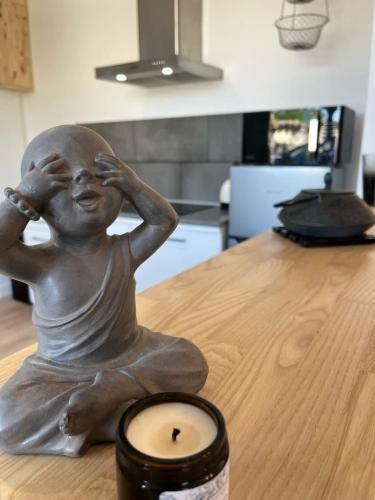 a statue of a woman sitting on a table with a candle at Charming house with garden, center of Puilboreau in Puilboreau