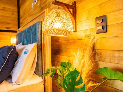 a bedroom with a bed and a lamp and a plant at Beach Suite cerca al Tayrona in Santa Marta