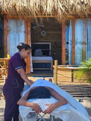 a woman standing next to a man laying in a bed at Beach Suite cerca al Tayrona in Santa Marta