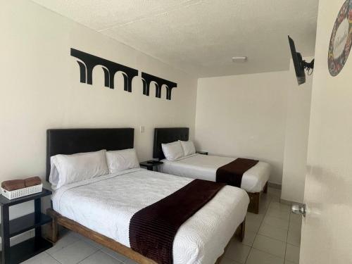 two beds in a hotel room with two beds at Alojamiento en Morelia in Morelia