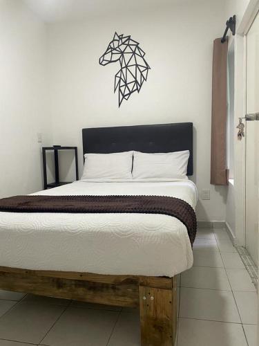 a bedroom with a large bed with a black headboard at Alojamiento en Morelia in Morelia