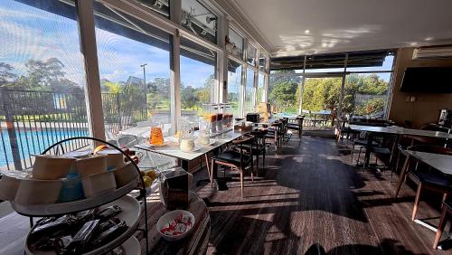 a restaurant with tables and chairs and a large window at The Select Inn Ryde in Sydney