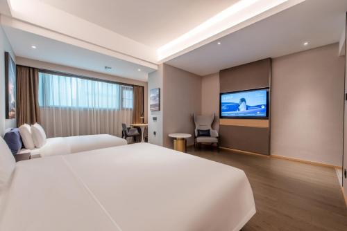 a hotel room with a large bed and a flat screen tv at Atour Hotel Shenzhen Luohu Vientiane City in Shenzhen