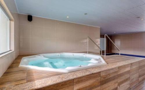 a jacuzzi tub in a large room with at Wyndhan Royal Hotel Resort Olimpia in Olímpia