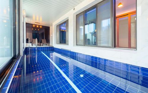 a swimming pool in a building with windows at NJ Pool Villa in Hoengseong