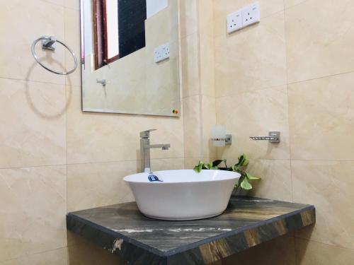 a bathroom with a white sink on a counter at Diyon'S Lodge in Ella