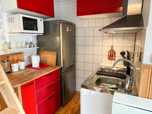 a small kitchen with a sink and red cabinets at 4 person holiday home in BORGHOLM in Borgholm