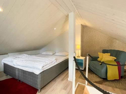 a small bedroom with a bed and a chair at 4 person holiday home in BORGHOLM in Borgholm