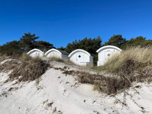 a row of white domes on the beach at 4 star holiday home in LÖDDEKÖPINGE in Löddeköpinge