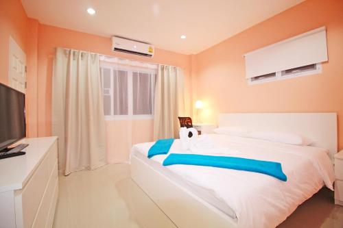 a bedroom with a large white bed with orange walls at Blue Wave Samui in Bophut 