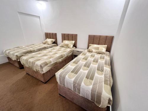 a room with three beds in a room at الفاخر للشقق الفندقيه in Al Mafraq