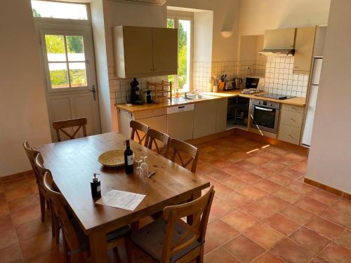 a kitchen with a wooden table and chairs and a table and a kitchen at Villa in France with Private Pool and Garden in Chalais