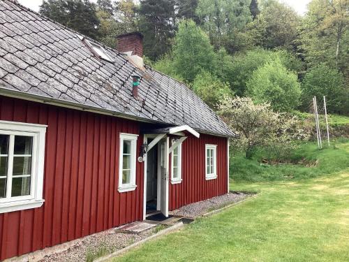 a red house with a white door in a yard at 6 person holiday home in VESSIGEBRO in Vessigebro