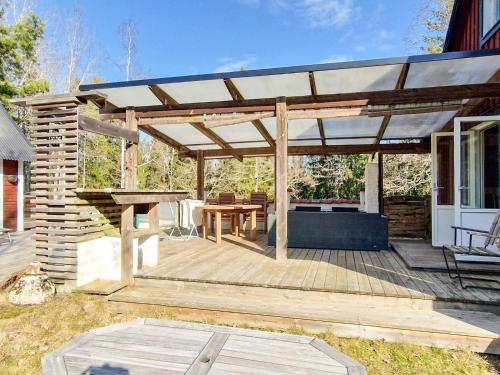 a wooden pergola with a table on a deck at 5 person holiday home in INGARÖ 
