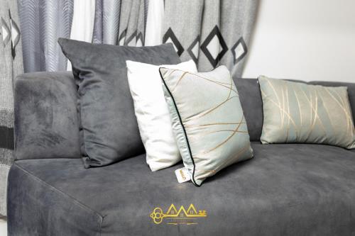 a gray couch with pillows on top of it at AM Apparts Suite Jacuzzi in Belas
