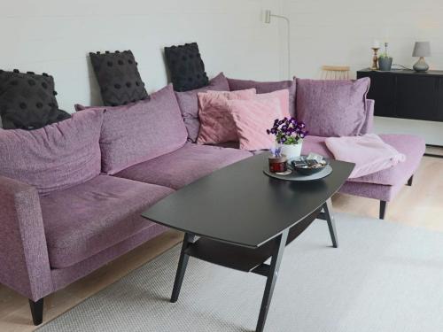 a purple couch and a table in a living room at 5 star holiday home in UGGLARP in Ugglarp