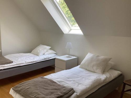 two beds in a room with a window at 4 star holiday home in Förslöv in Förslöv