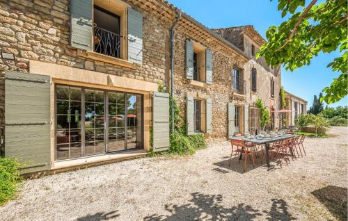 un patio avec une table et des chaises devant un bâtiment dans l'établissement Awesome Home In Travaillan, à Travaillan