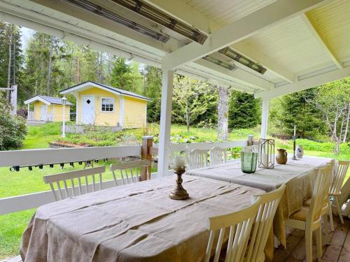 a long table on a porch with chairs at 5 star holiday home in Gräddö in Gräddö