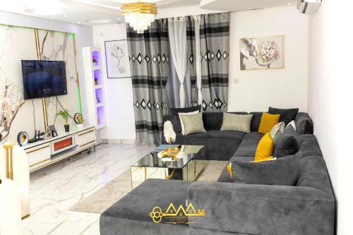a living room with a couch and a tv at AM Apparts Suite Jacuzzi in Belas