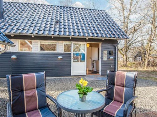a table and two chairs with a vase of flowers at 4 star holiday home in in Give