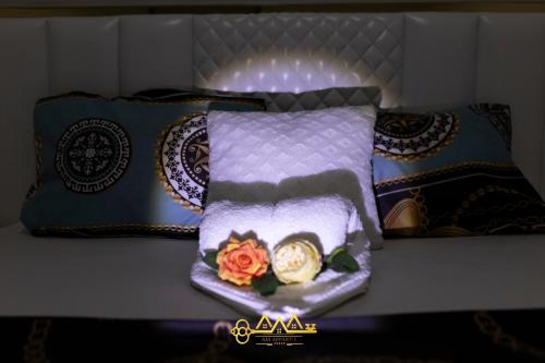 a bed with a pillow with a flower on it at AM Apparts Suite Jacuzzi in Belas