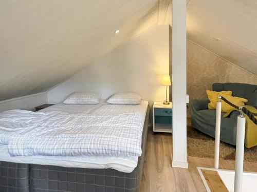 a bedroom with a bed and a couch in a attic at 4 person holiday home in BORGHOLM in Borgholm