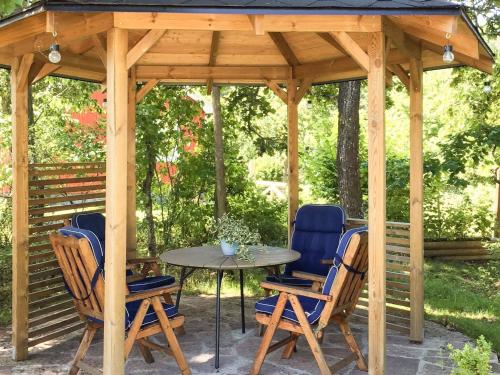 a wooden gazebo with a table and chairs at 4 person holiday home in BORGHOLM in Borgholm