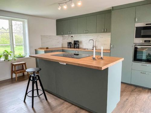 a kitchen with green cabinets and a wooden counter top at 4 star holiday home in HALTORP in Halltorp