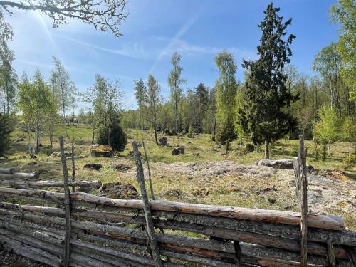 a wooden fence in a field with trees at 6 person holiday home in Kristdala in Kristdala