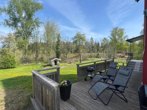 a deck with two chairs and a grill on it at 6 person holiday home in Kristdala in Kristdala