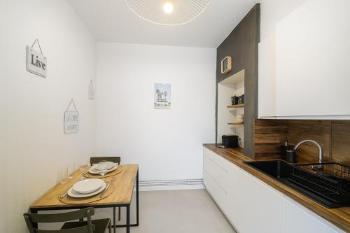 - une cuisine avec une table en bois et un évier dans l'établissement Place du Capitole à 2 min à pied - Séjour tout confort avec Wifi et check-in autonome, à Toulouse
