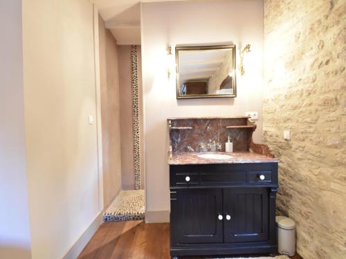 une salle de bain avec un lavabo noir et un miroir dans l'établissement Manor in Normandy with Spa and Pool, cleaning included, à Lantheuil