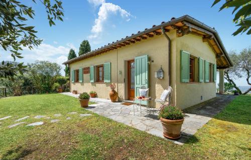 Una pequeña casa con persianas verdes y un patio. en La Piana, en Mommio
