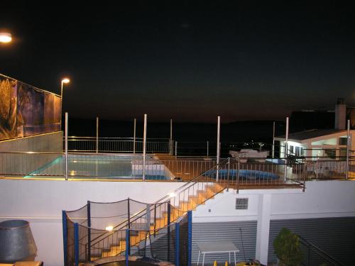 a building with a deck with a swimming pool at night at Aparthotel Pecic in Gradac