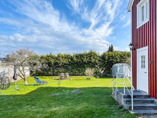 a red house with a lawn with a yard with a house at 4 person holiday home in Rättvik in Västervik