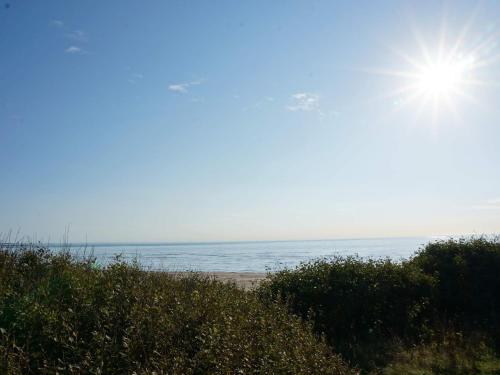 a beach with the sun shining over the ocean at 5 star holiday home in UGGLARP in Ugglarp