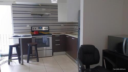 a kitchen with a stove and a table and chairs at Apartamento Ciudad de Guatemala, Zona 4, 1 Parqueo Gratis, Mejor Vista en 4 Grados Norte, 4 Camas in Guatemala