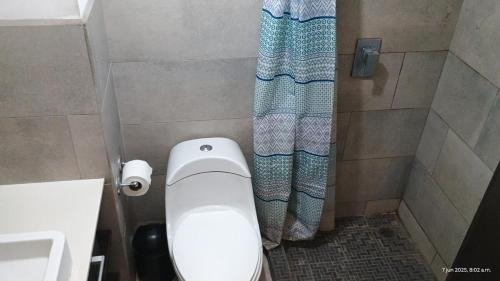 a bathroom with a toilet and a shower curtain at Apartamento Ciudad de Guatemala, Zona 4, 1 Parqueo Gratis, Mejor Vista en 4 Grados Norte, 4 Camas in Guatemala