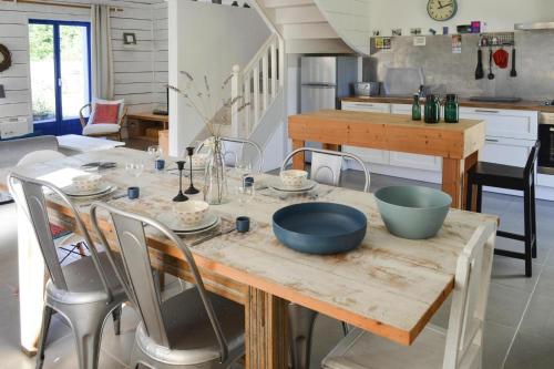 - une cuisine avec une table en bois et des bols dans l'établissement Holiday Home in Brittany near Sandy Beaches, cleaning included, à Locquirec