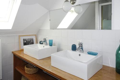 une salle de bain avec deux lavabos et un miroir dans l'établissement Holiday Home in Brittany near Sandy Beaches, cleaning included, à Locquirec