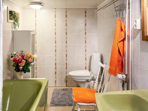 a bathroom with a green tub and a toilet at Charming Garden Cottage in Levide in Hemse